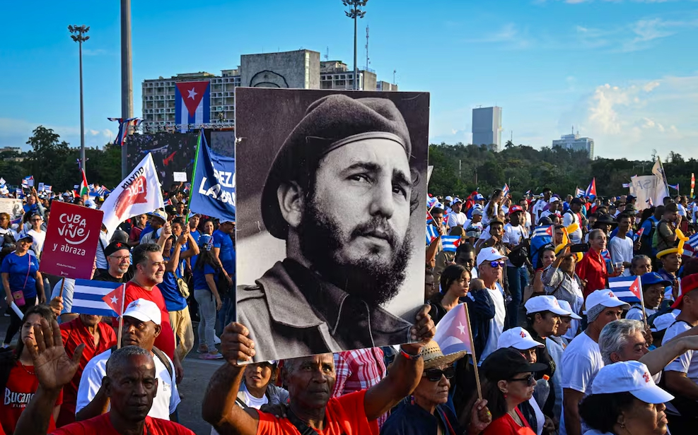 Una mujer sostiene un cartel con la imagen del líder cubano Fidel Castro durante la conmemoración del primero de mayo en la Plaza de la Revolución de La Habana, Cuba, el 1 de mayo de 2025. Foto: AFP