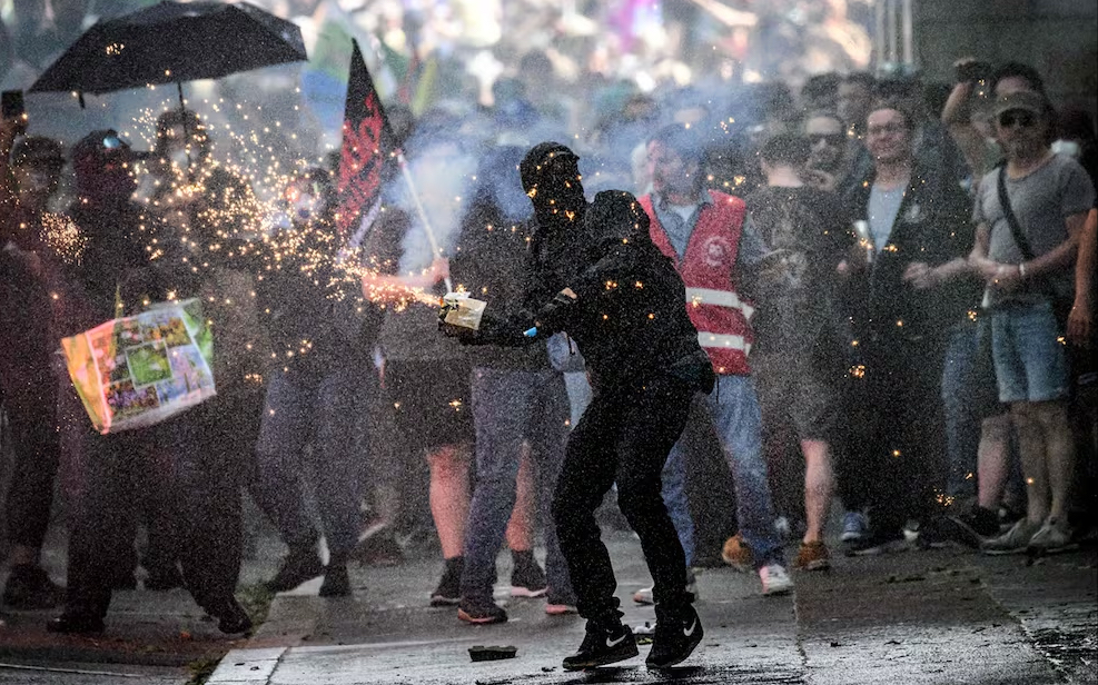 Un manifestante es rociado con agua mientras lanza fuegos artificiales a la policía antidisturbios durante una manifestación por el Día Internacional del Trabajo en la ciudad francesa de Nantes, el jueves 1 de mayo de 2025. Foto: AFP