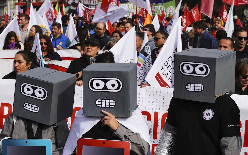 Personas con cabezas de robot de cartón participan en una marcha por el Día Internacional del Trabajo en Santiago, Chile, el jueves 1 de mayo de 2025. Foto: AP