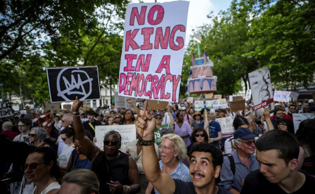 Un hombre con una pancarta que dice "Sin rey en una democracia" participa en la protesta mundial llamada "Sin reyes" en París, Francia, contra las políticas antimigrantes de Trump, el 14 de junio de 2025. Foto: AP