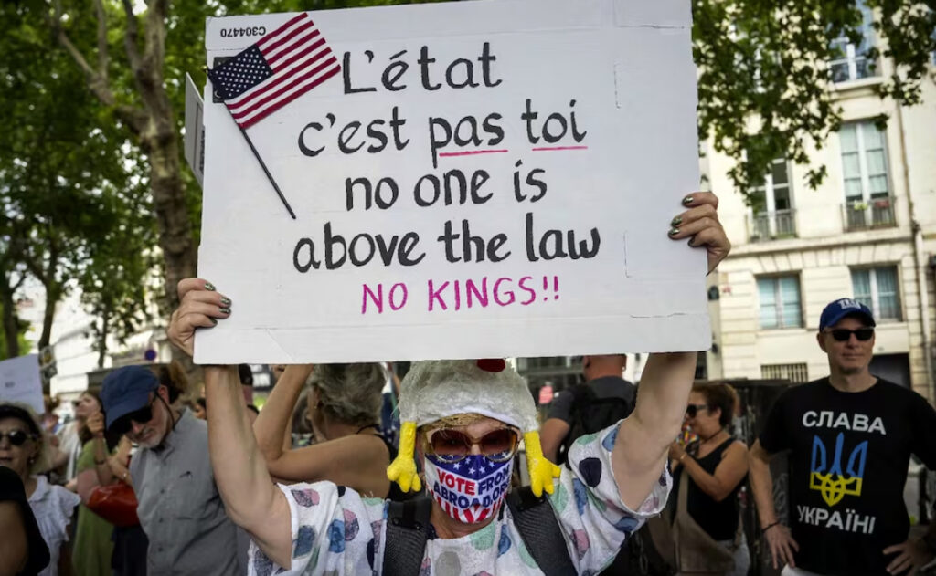 Una persona sostiene una pancarta con la leyenda "Nadie está por encima de la ley" participa en la protesta "Sin reyes" en París, el domingo 14 de junio de 2025. Foto: AP