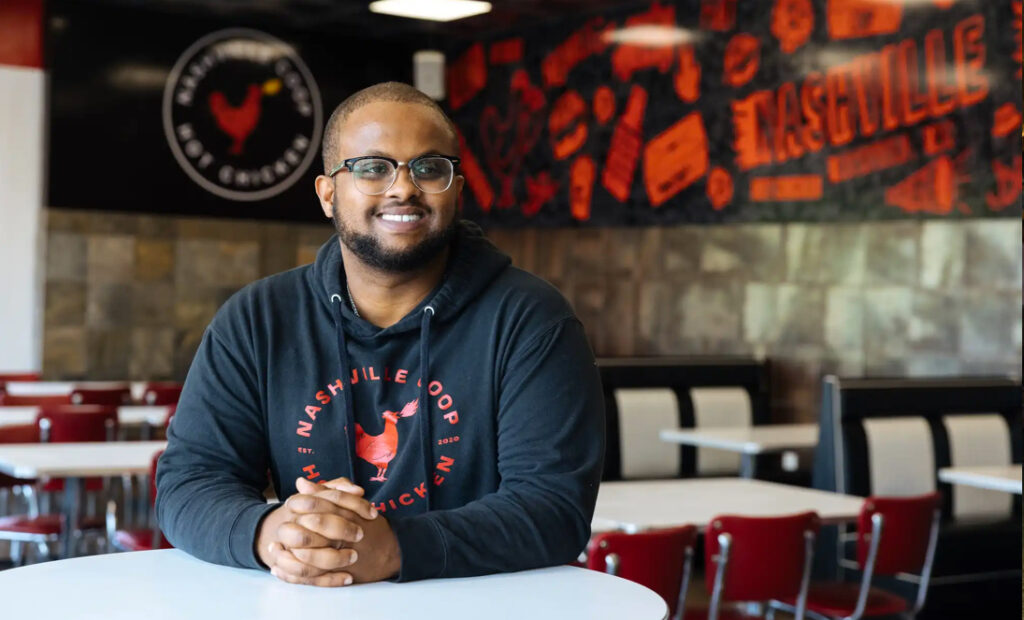 Arif Ahmed, sentado en uno de sus restaurantes el martes, abrió Nashville Coop con su familia como food truck. Ha crecido hasta tener tres tiendas físicas, incluyendo esta en Richfield. Carly Danek para MPR News
